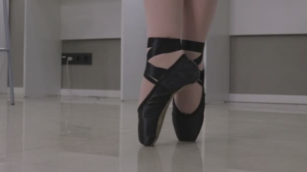 Вид балерины, стоящей на кончиках пальцев ног в паре балетных туфель — стоковое видео