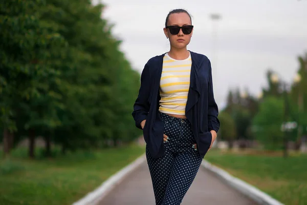 Confiant ajustement jeune femme en lunettes de soleil sur la passerelle dans le parc — Photo