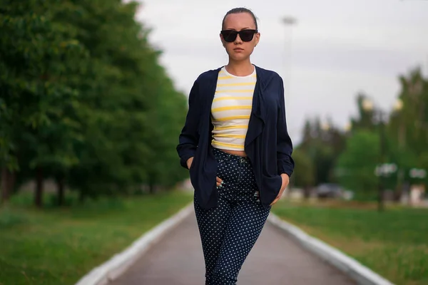 Confiant ajustement jeune femme en lunettes de soleil sur la passerelle dans le parc — Photo