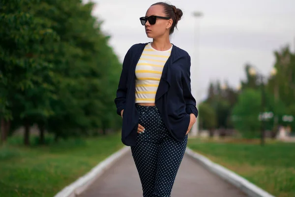 Confiant ajustement jeune femme en lunettes de soleil sur la passerelle dans le parc — Photo