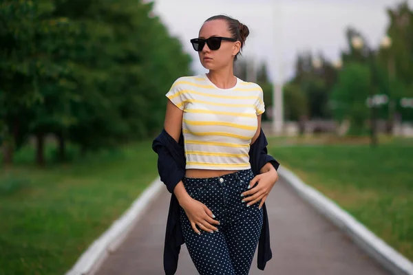 Confiant ajustement jeune femme en lunettes de soleil sur la passerelle dans le parc — Photo