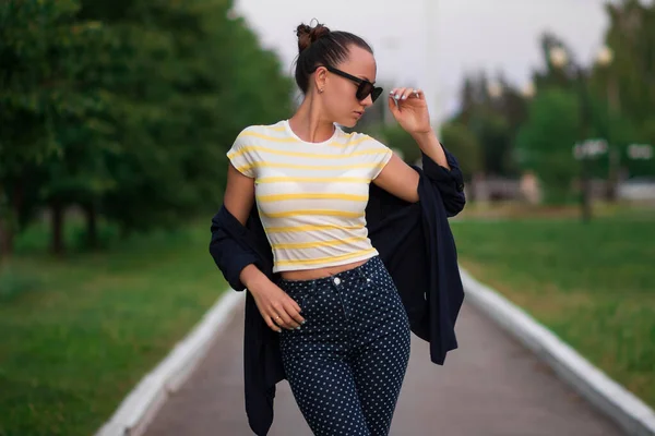 Confiant ajustement jeune femme en lunettes de soleil sur la passerelle dans le parc — Photo