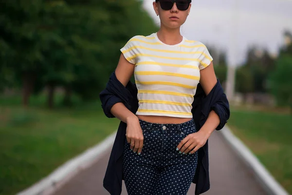 Confiant ajustement jeune femme en lunettes de soleil sur la passerelle dans le parc — Photo