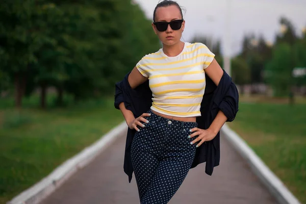 Confident fit young woman in sunglasses on walkway in park — 스톡 사진
