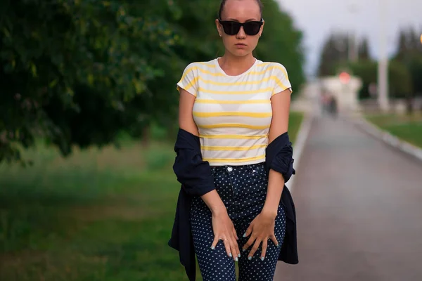 Confident fit young woman in sunglasses on walkway in park — 스톡 사진