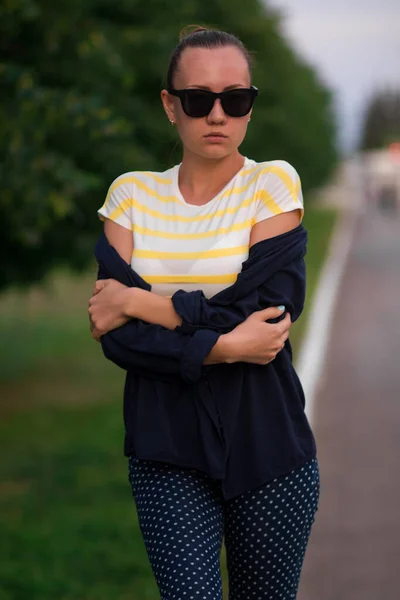 Confiant ajustement jeune femme en lunettes de soleil sur la passerelle dans le parc — Photo
