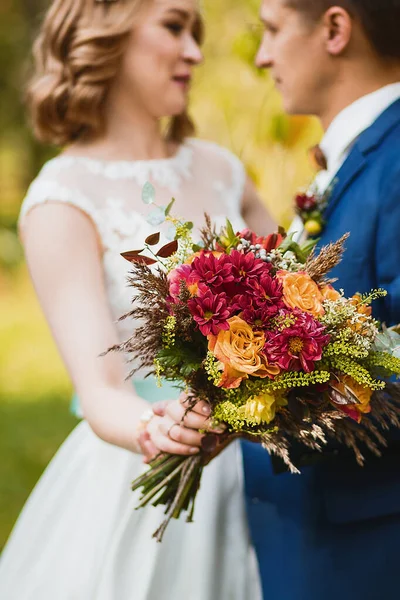 Amazing wedding bouquet with vibrant flowers and green and brown herbs — Stock Photo, Image