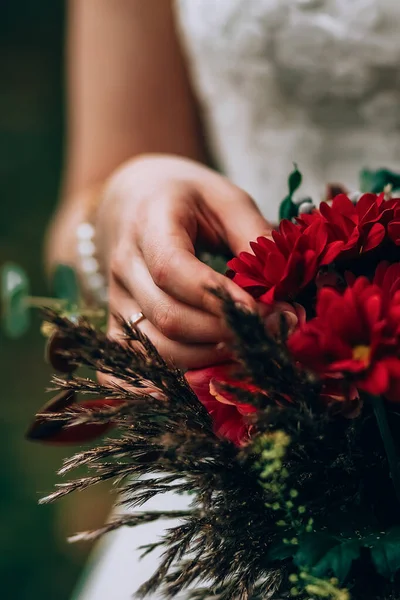 Mazzo di tenuta sposa con fiori vinosi in composizione con erbe verdi e marroni — Foto Stock