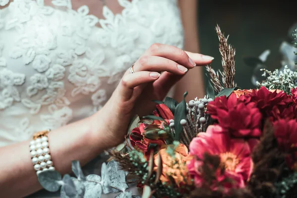 Mazzo di tenuta sposa con fiori vinosi in composizione con erbe verdi e marroni — Foto Stock