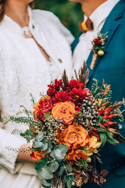 Bouquet de mariage incroyable avec des fleurs vibrantes et des herbes vertes et brunes — Photo