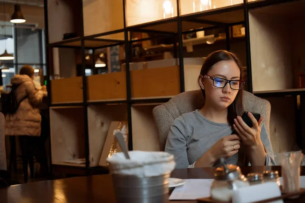 Junge Frau benutzt Smartphone im Café — Stockfoto