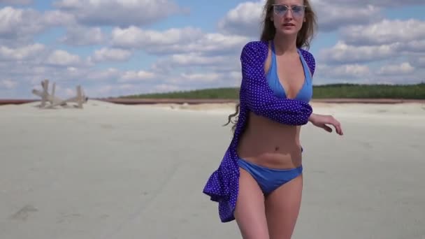 Jeune femme marchant levant la main et tournant en maillot de bain élégant léger — Video
