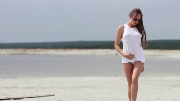 Гаряча жінка захоплююче ходить на топі в піску — стокове відео