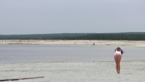 Sensuell kvinna som går längs stranden på tå visar badkläder — Stockvideo