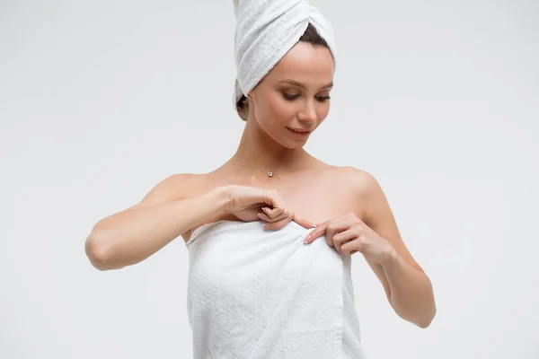 Charming woman with white towel on head straightening fingernail — Stock Photo, Image