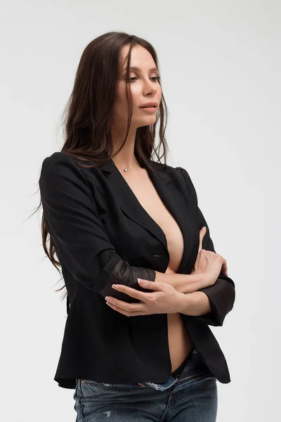 Provokante Frau im schwarzen Anzug auf nacktem Körper, die wegschaut — Stockfoto