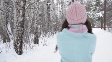 Kış ormanlarına doğru yürüyen zarif genç bir kadın.