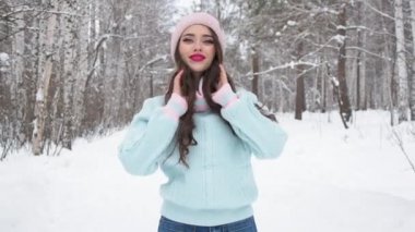 Kış ormanlarına doğru yürüyen zarif genç bir kadın.