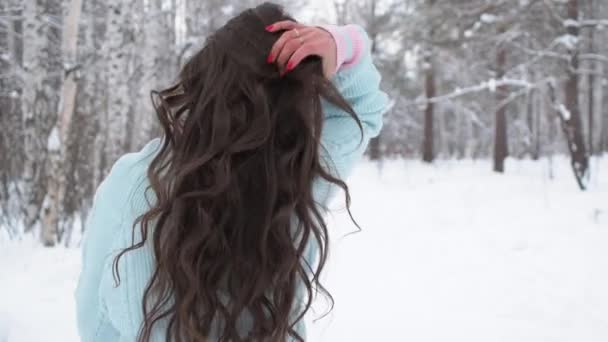 Stijlvolle jonge vrouw op weg naar winterbos — Stockvideo