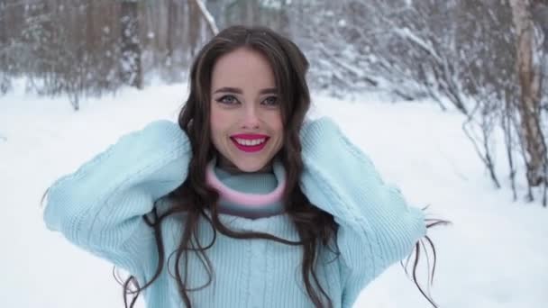 Stylish young woman walking towards winter forest — Stock Video