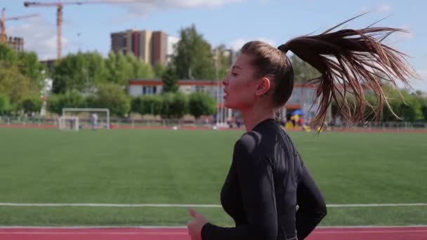 市内のスタジアムで走るスリムな女性 — ストック動画