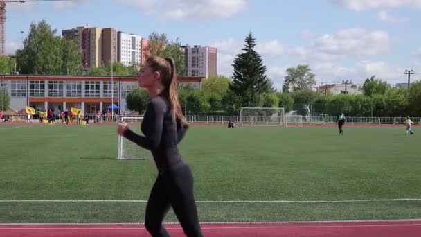 Тонка жінка біжить на міському стадіоні — стокове відео