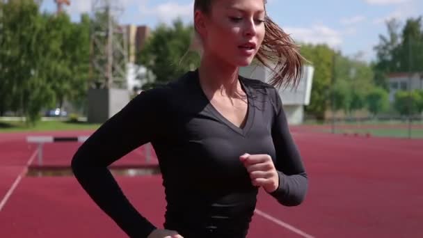 Mujer delgada corriendo en el estadio de la ciudad — Vídeo de stock