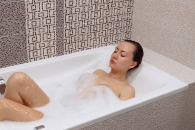 Hoş bir kadın köpük banyosundan zevk alıyor..