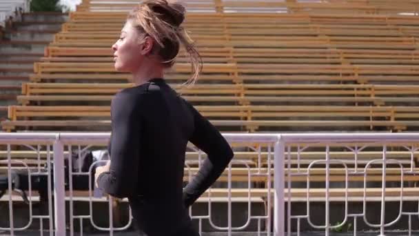 Slanke vrouw die in het stadion van de stad loopt — Stockvideo