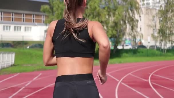 Mulher magro correndo em pista de corrida em sol — Vídeo de Stock