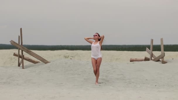 Горячая женщина неблагодарно ходит на цыпочках по песку — стоковое видео