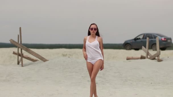 Hot woman ingratiatingly walking on tiptoe in sand — Stock Video