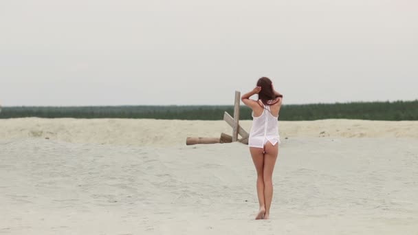 Sensual mujer caminando a lo largo de la playa de puntillas mostrando trajes de baño — Vídeos de Stock