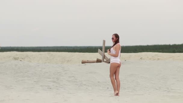 Sensual mujer caminando a lo largo de la playa de puntillas mostrando trajes de baño — Vídeos de Stock