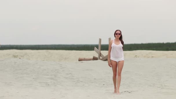 Mulher quente ingratiatingly andando na ponta dos pés na areia — Vídeo de Stock