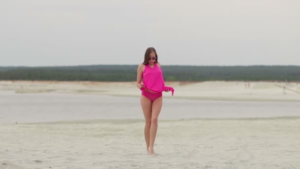 Mulher quente ingratiatingly andando na ponta dos pés na areia — Vídeo de Stock