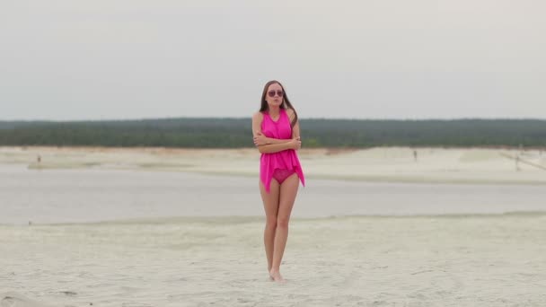 Hot woman ingratiatingly walking on tiptoe in sand — Stock Video