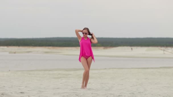 Sinnliche Frau, die auf Zehenspitzen am Strand entlang läuft und Badebekleidung zeigt — Stockvideo