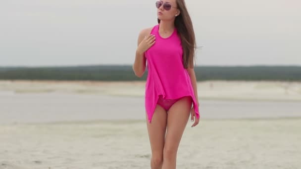 Hot woman ingratiatingly walking on tiptoe in sand — Stock Video