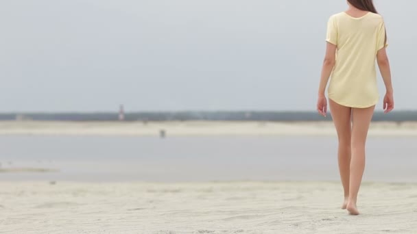 Sensual mujer caminando a lo largo de la playa de puntillas mostrando trajes de baño — Vídeo de stock