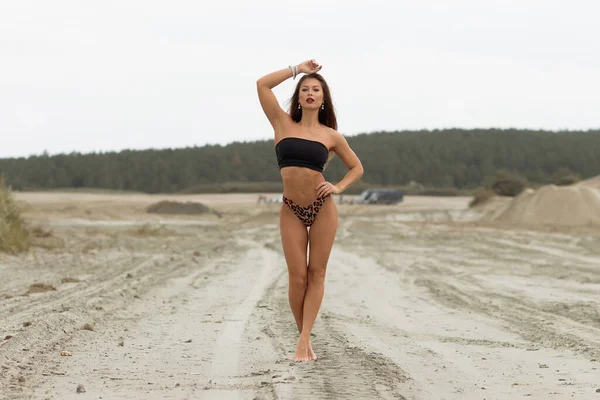Sensual hembra delgada en traje de baño negro en la playa — Foto de Stock