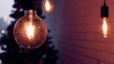 Dekoratif sicim lambaları sallanıyor ve geceleri dışarıda parlıyor. Ilık ışıklandırma, klasik lamba çelengi ya da cam fener, elektrik ampulleri, tatil için dekorasyon.