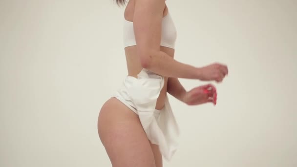 Corpo perfeito jovem mulher em um fundo branco em lingerie sexy — Vídeo de Stock