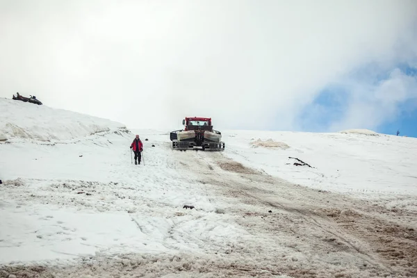 Kırmızı ratrak Elbrus karla kaplı yamacında