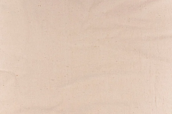 De textuur van natuurlijk doek. Achtergrond van ruwe stof met kleine plooien. — Stockfoto
