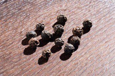 Tahta bir masada bir avuç kokulu karabiber..