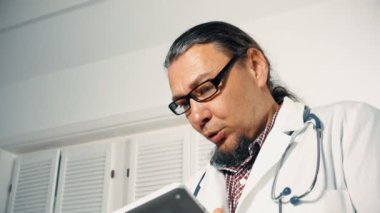 İstişare Odaya giren ve hasta holding dijital tablet için konuşurken erkek doktor