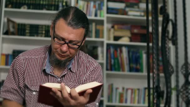 Casual Middle Aged Man Eyeglasses Reading Book Drinking Tea Bookshelves — Stock Video