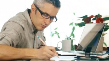 Casual adam ev ofis içinde laptop üzerinde çalışıyor