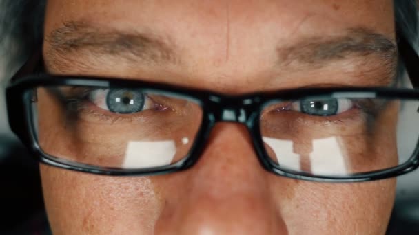 Yakın çekim yetişkin adamın gözlük ve mavi gözlü okuma — Stok video